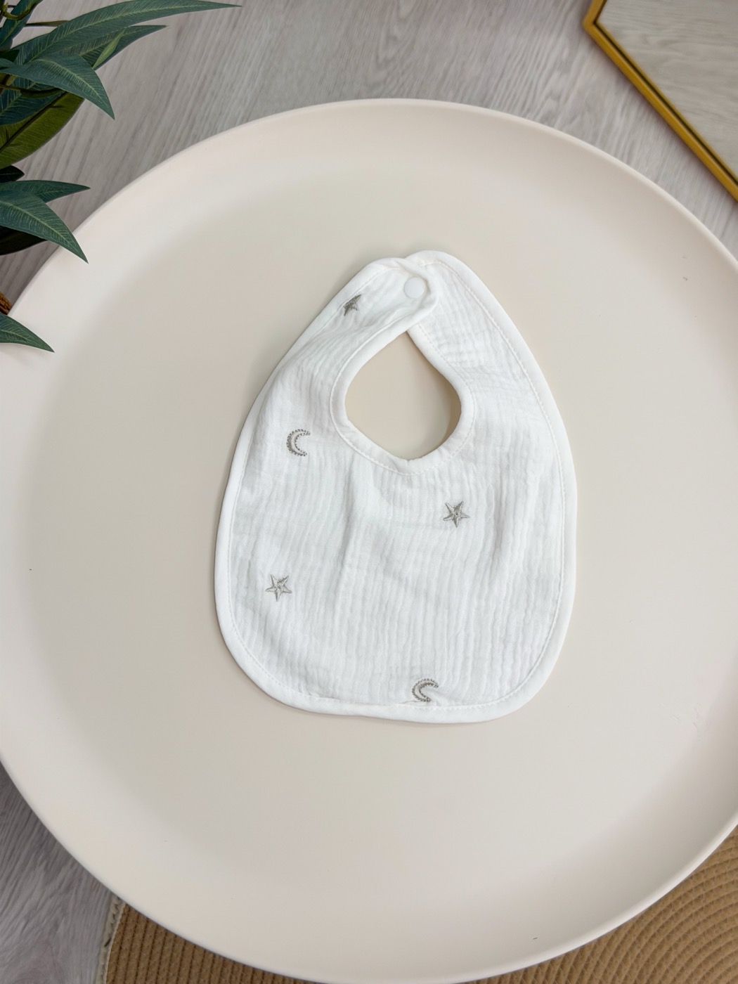 Babero con broche · estrellas y lunas, marfil