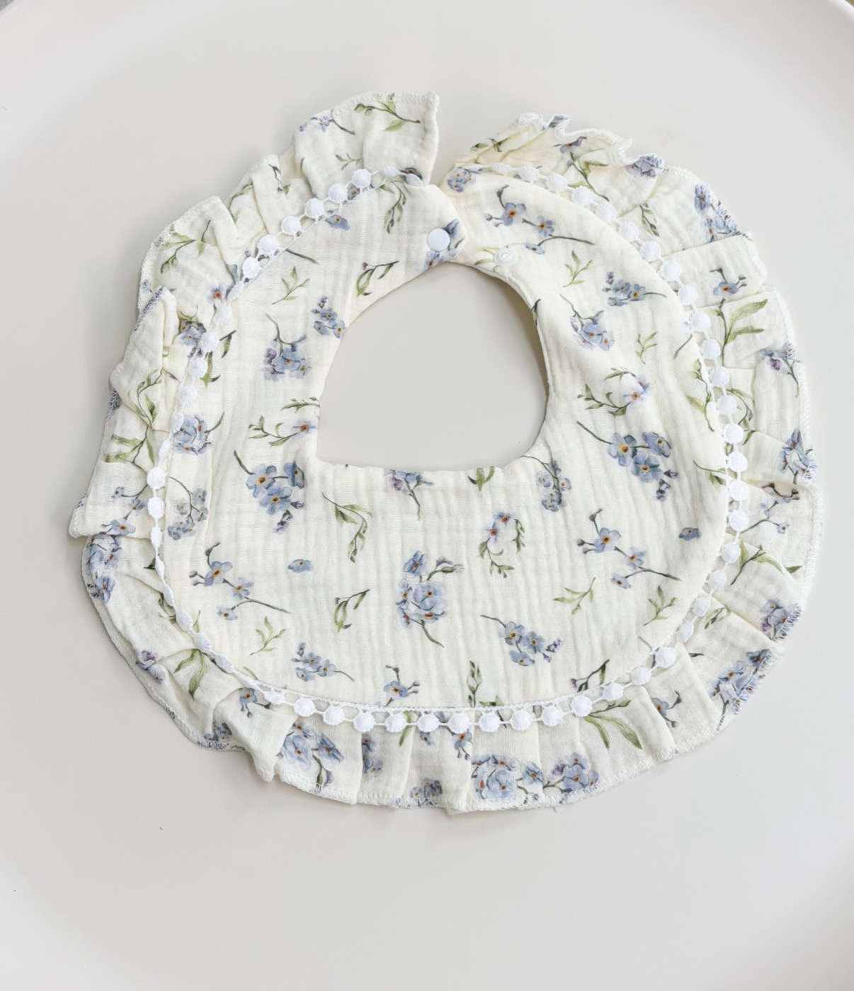 Babero con volante · flores azules